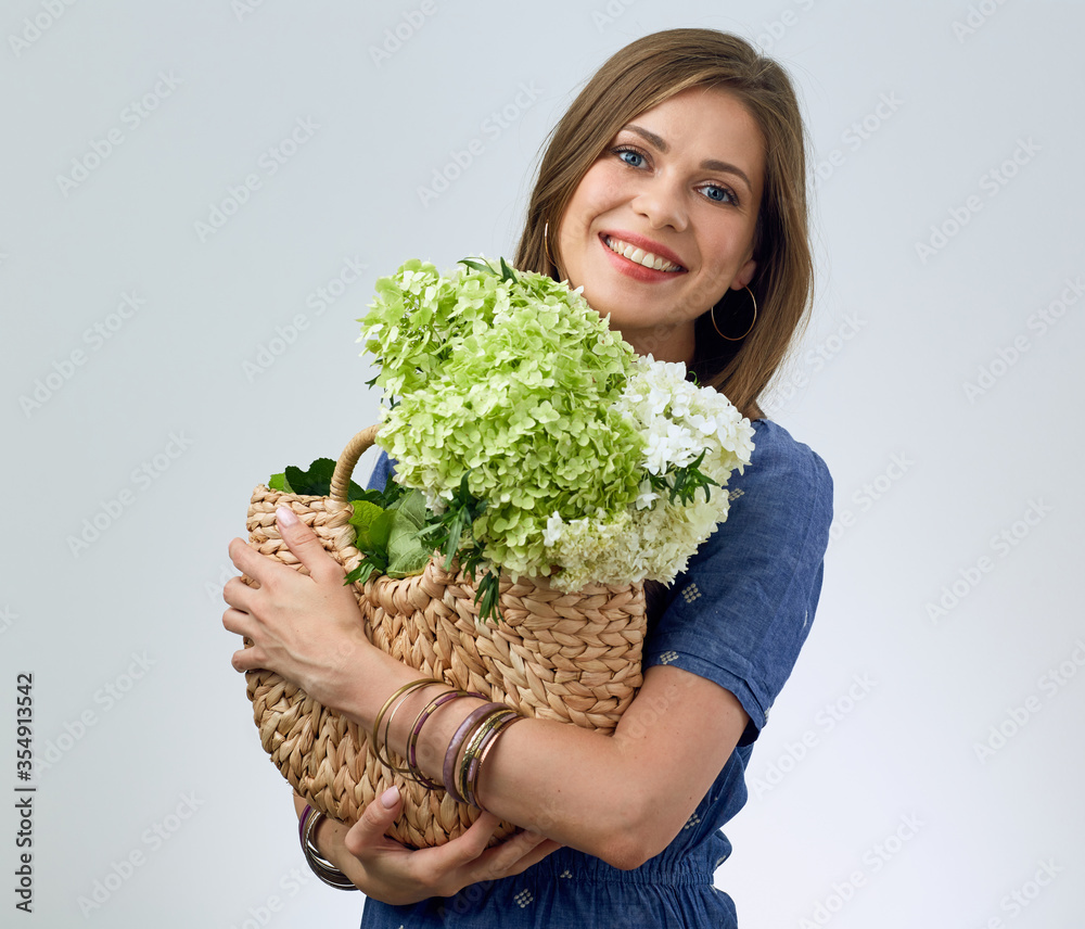 woman holding straw bag with white and green flowers. woman holding straw bag with white and green flowers.