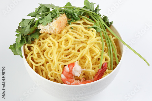 Fresh yellow egg noodle prawn tofu coriander leaf in bowl on whit background