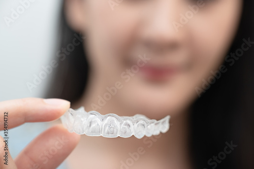Woman show orthodontic silicone trainer. Mobile orthodontic appliance for dental correction. tooth whitening systems.