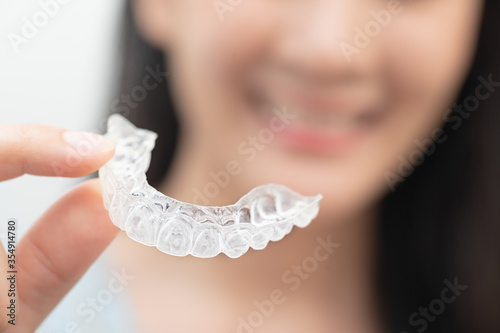 Woman show orthodontic silicone trainer. Mobile orthodontic appliance for dental correction. tooth whitening systems.