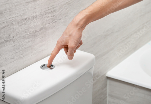 Konstfotografi Flushing toilet bowl with button