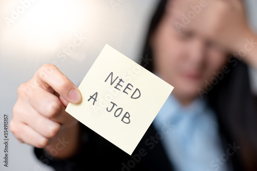 women holding need a job text on paper note pad. Jobless concept.