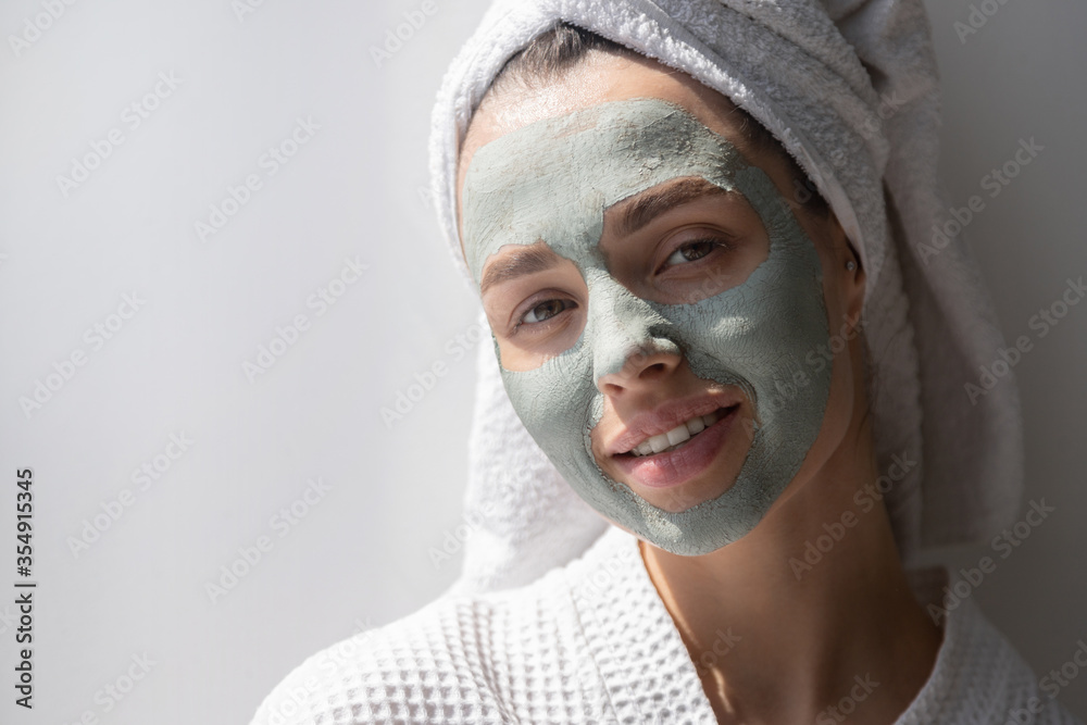 Woman with grey natural organic cosmetic clay mask to rejuvenate facial skin. Woman with grey natural organic cosmetic clay mask to rejuvenate facial skin.