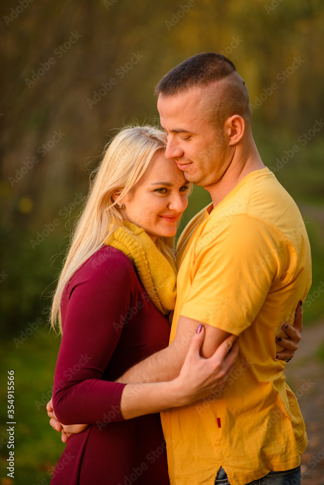 Fototapeta premium Mężczyzna i kobieta przytulają się w jesiennym parku.