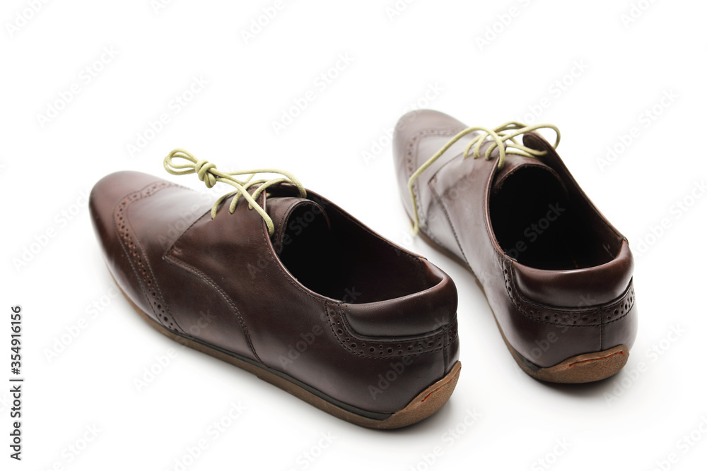 Two brown shoes with untied laces on a white isolated background Two brown shoes with untied laces on a white isolated background