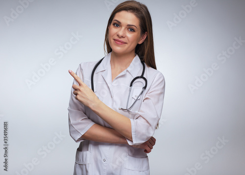 Woman doctor dressed white uniform pointing with finger.