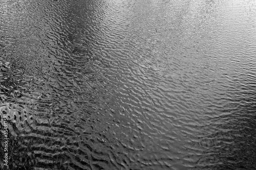 Waves on lake water from top. Black and white