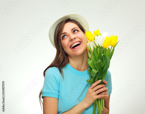 Happy laughing woman holding tulips flowers and looking up.