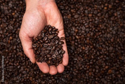 Fresh roasted coffee beans in hands from above