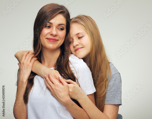 Daughter hugs his mother isolated studio portrait