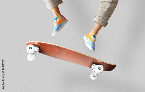 Skateboarder in colored sneakers jumping on a skateboard