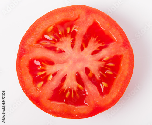 Slice of fresh tomato closeup, isolated on white,