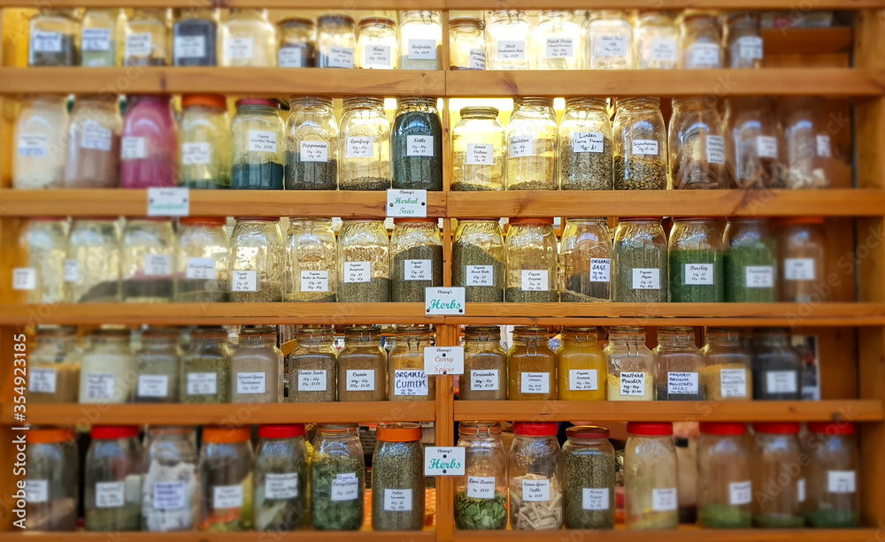 Jars of herbs and spices on shelves at market.