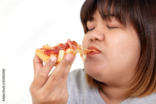 Fat Asian woman eating pizza happily. The concept of weight loss  choosing foods that are good for the body and health. White background. isolated