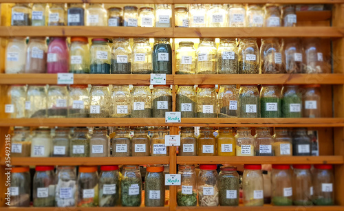 Jars of herbs and spices on shelves at market.
