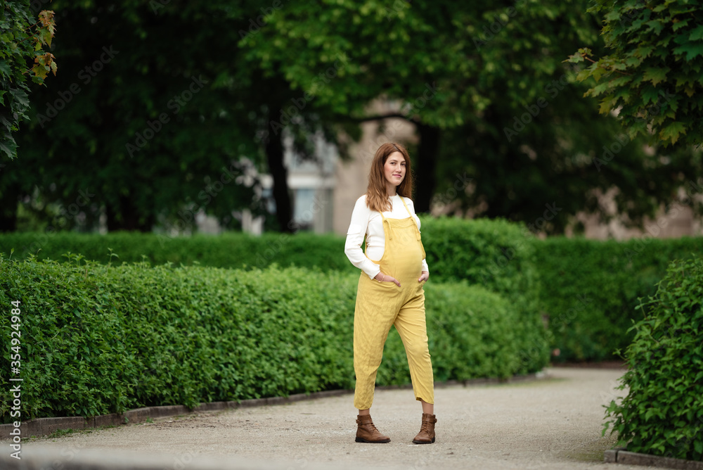 Beautiful pregnant girl walking in the Park. Beautiful pregnant girl walking in the Park.