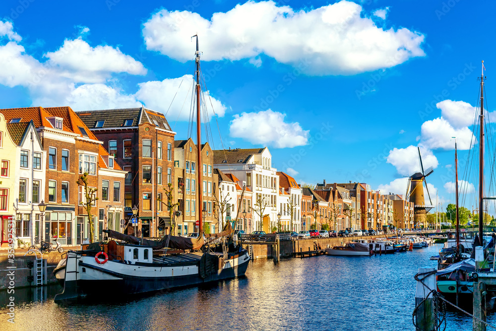 Old historic district Delfshaven with wildmill and houseboats in Rotterdam, South Holland, The Netherlands. Summer sunny day.