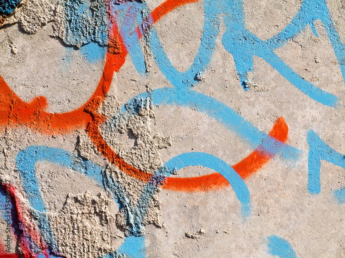 Landscape style. Grungy concrete surface with cracks, scratches traces of blue and red paint on the walls. Great background or texture.