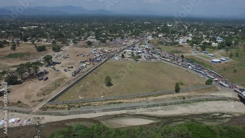 Panning over Dajabon bridge and river between Haiti and Dominican Republic. Aerial photo