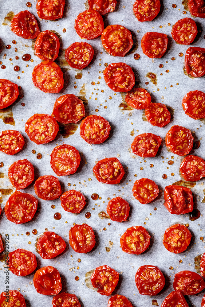 Sun-dried cherry tomatoes with olive oil and balsamic vinegar on baking paper. Top view, food background Sun-dried cherry tomatoes with olive oil and balsamic vinegar on baking paper. Top view, food background