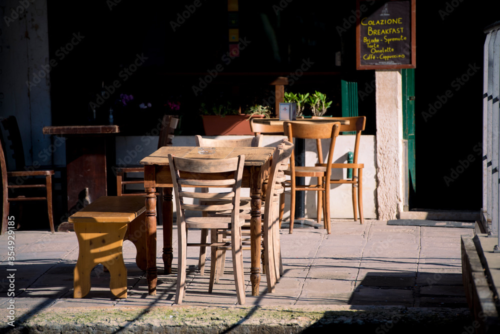 Empty tables and chairs in Venice cafe showing effects of economic crisis caused by Coronavirus