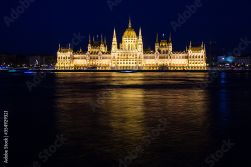 Illuminated Budapest parliament building at night with dark sky and reflection in Danube river © bartoshd