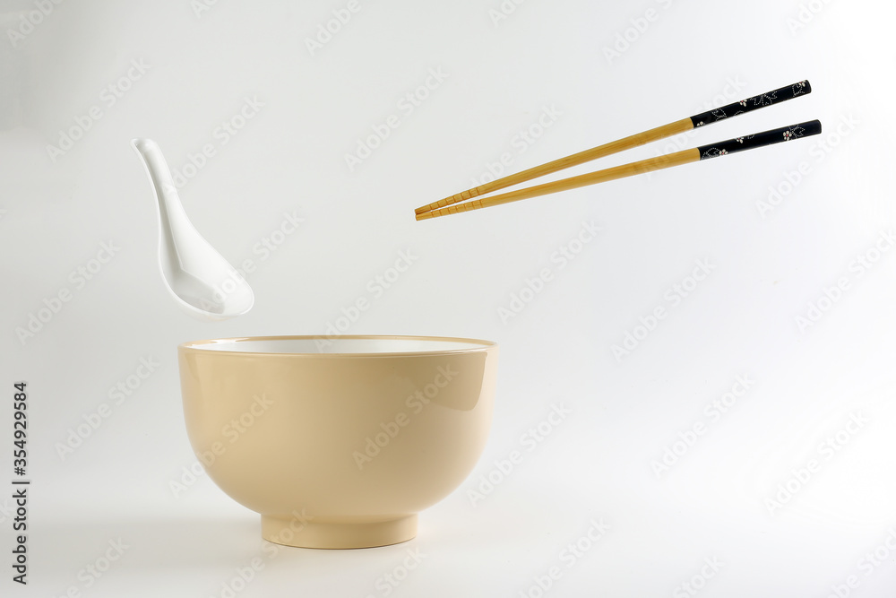 Empty oriental Japanese Chinese soup bowl spoon chopstick elevated flying in air off white Empty oriental Japanese Chinese soup bowl spoon chopstick elevated flying in air off white