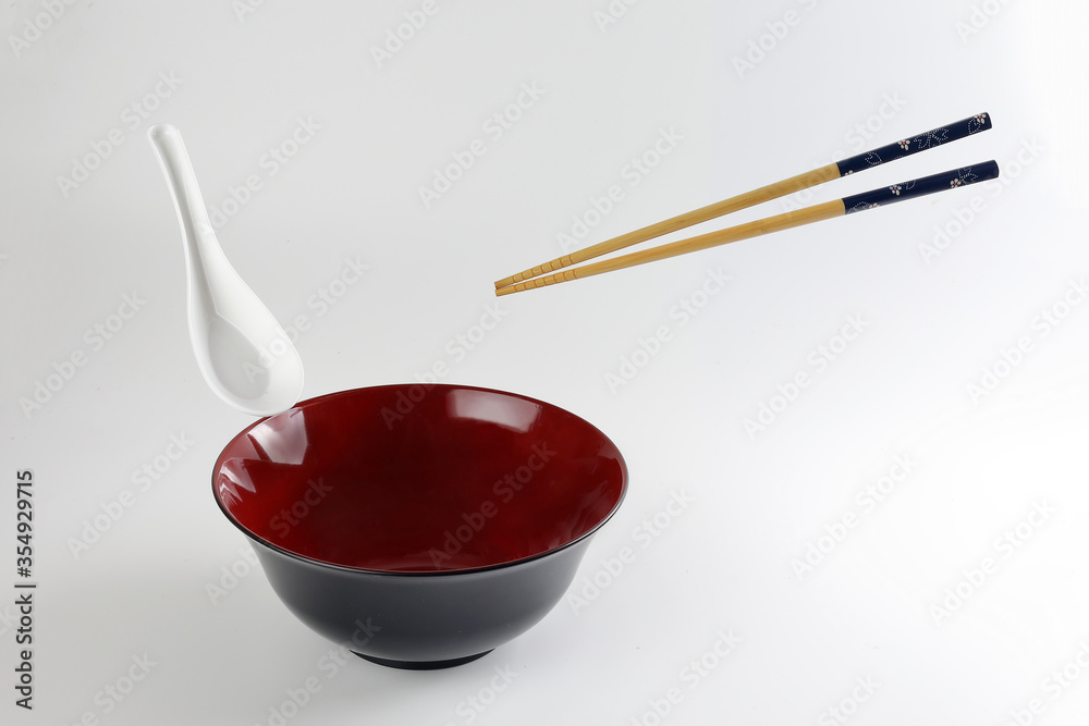 Empty oriental Japanese Chinese soup bowl spoon chopstick elevated flying in air red black white Empty oriental Japanese Chinese soup bowl spoon chopstick elevated flying in air red black white