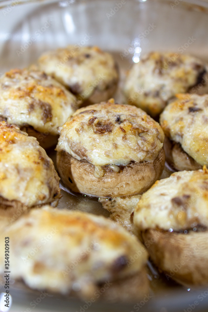 Stuffed mushrooms stuffed with cheese, mushroom stalks and onions. In a baking dish.