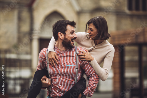 Young couple in the rain looking at eachother while smiling