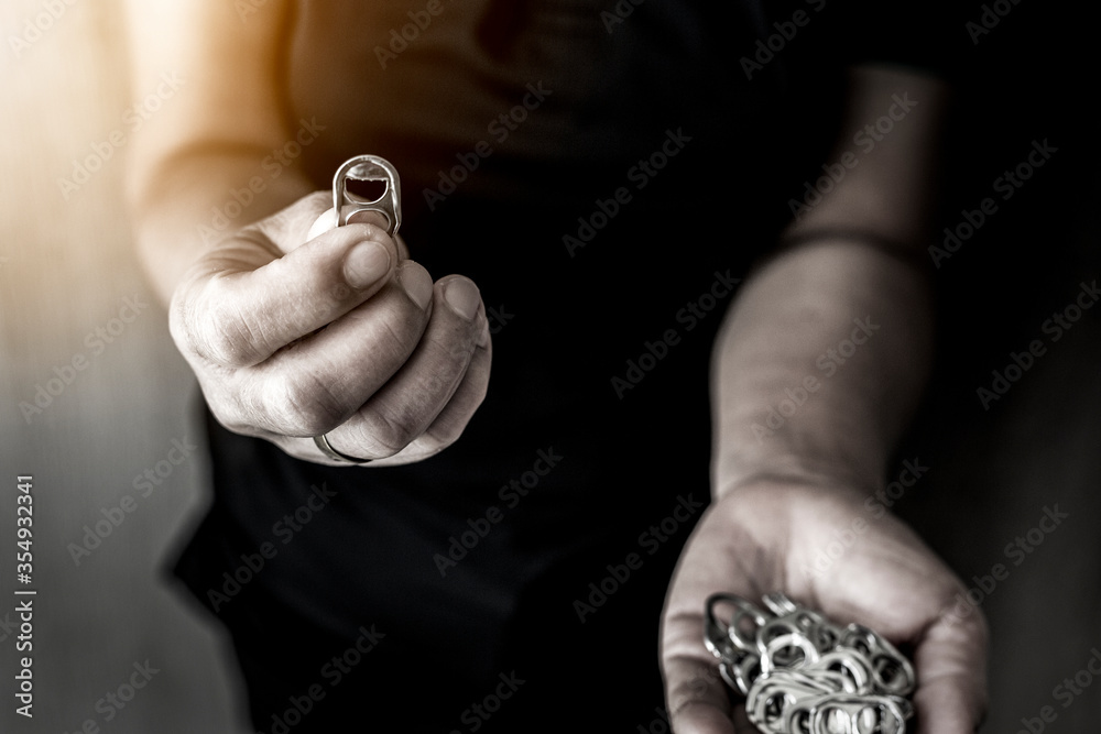Fototapeta premium Hand holding stack of ring pull aluminum of cap cans.Raw materials for prosthetics and prosthetics for the disabled concept.