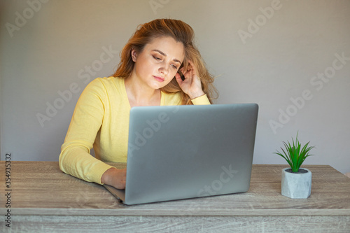 Tired woman with a laptop .Problem with a laptop. Girl with a laptop sits at the table