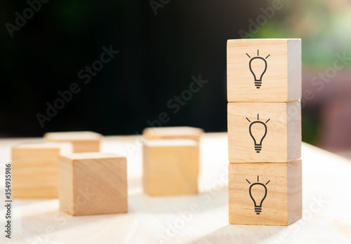 Light bulb icon on wood cube stacking