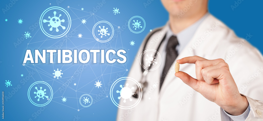 Doctor giving pill with ANTIBIOTICS inscription, coronavirus concept Doctor giving pill with ANTIBIOTICS inscription, coronavirus concept