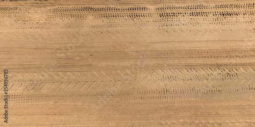 view from above on texture of gravel road with car tire tracks