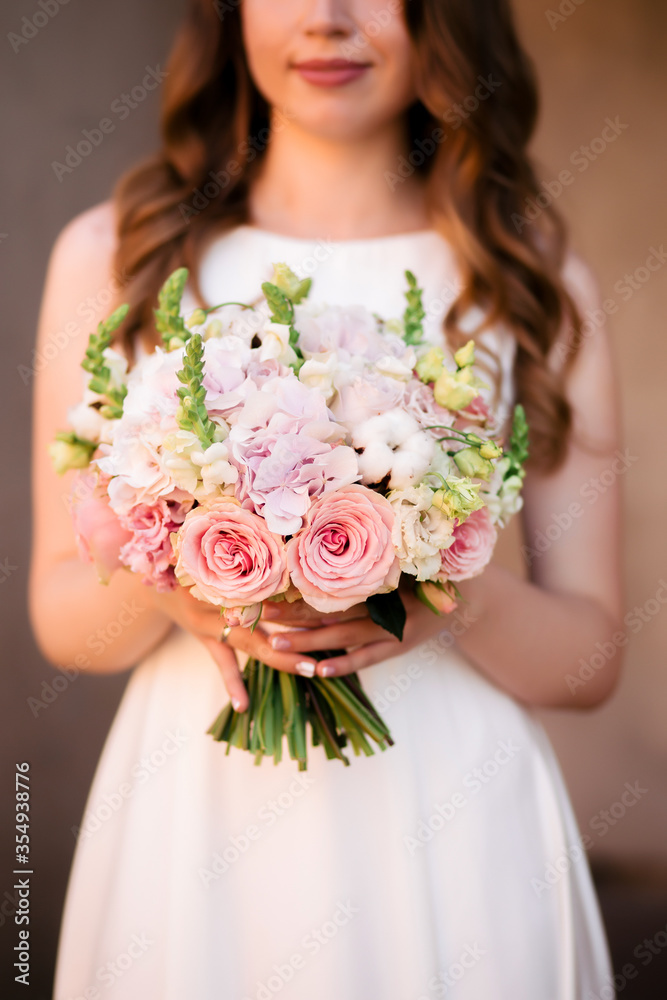 Wedding bouquet of roses at the bride's hands
