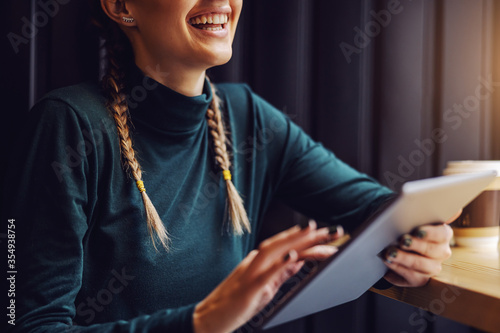 Photography Closeup of girl sitting in cafeteria and surfing on internet over tablet
