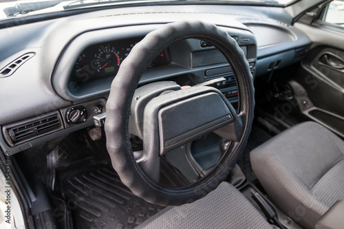 Novosibirsk, Russia - 05.20.2020: Control panel and the center console of Russian car with steering wheel and turn signal knobs and a wiper with gray air conditioning holes made of inexpensive plastic