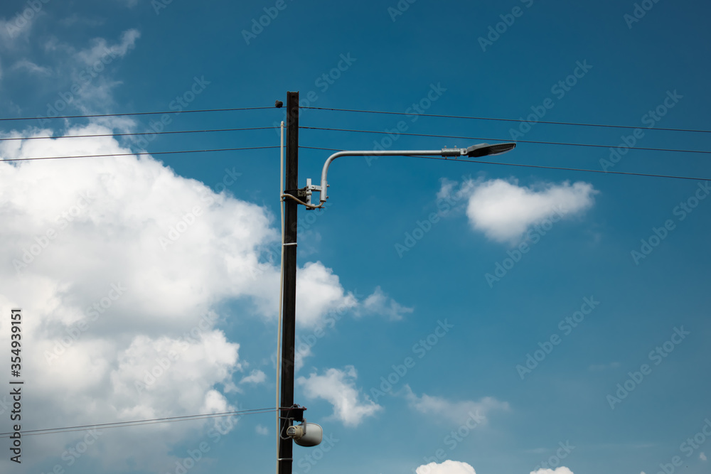street lamp pole with small speaker on blue summer sky background street lamp pole with small speaker on blue summer sky background