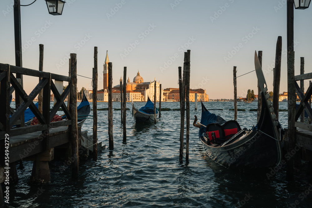 Gondolas without people are parked on the embankment of the Grand Canal of Venice, Italy.
