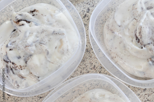  Homemade cookies and cream yogurt put into individual containers on a domestic kitchen counter.
