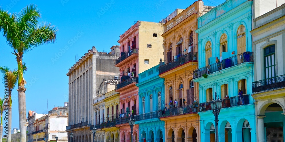 Colorful colonial houses in Havana, Cuba, palm trees, blue sky background, a sunny day