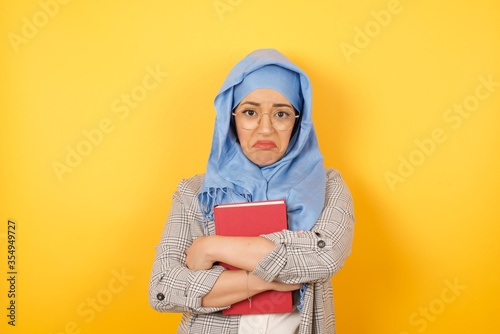 Beautiful sad young muslim woman wearing hijab crying desperate and depressed with tears on her eyes suffering pain and depression and sadness. Facial expression and emotion concept. © Jihan