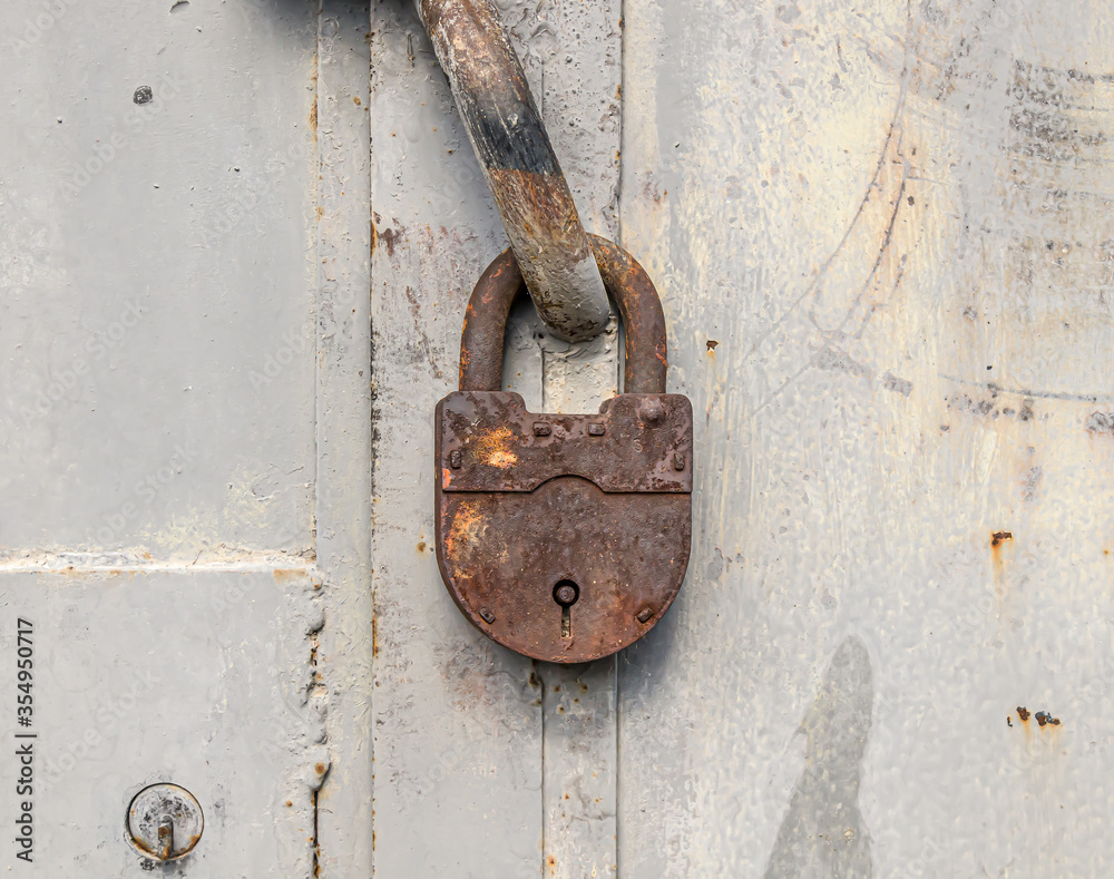 Rusty old padlock on an old metal door Rusty old padlock on an old metal door