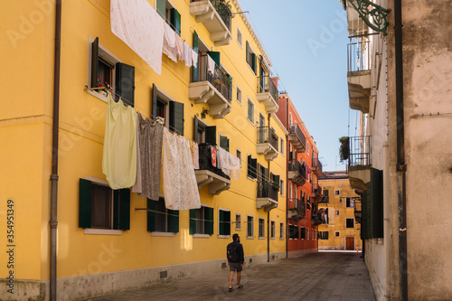 Only one tourist is walking on the street of Cannaregio district in Venice, Italy.