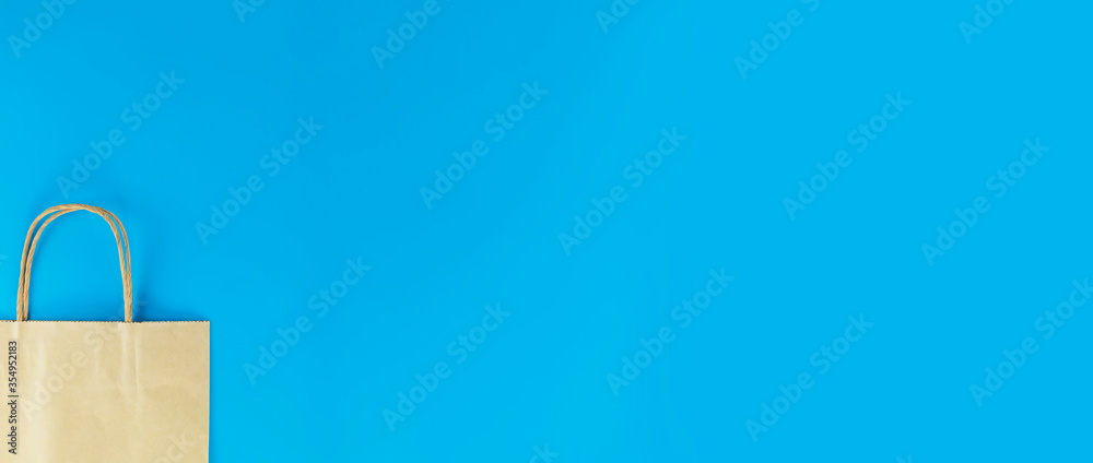 Half paper shopping bag isolated on blue background with copy space Half paper shopping bag isolated on blue background with copy space