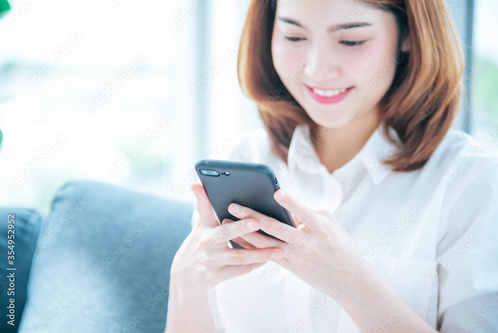 Asian woman using smartphone reading online social media shopping online website on smartphone with smile face. Happiness asian woman holding cellphone checking mail read Blog vlog social media Asian woman using smartphone reading online social media shopping online website on smartphone with smile face. Happiness asian woman holding cellphone checking mail read Blog vlog social media