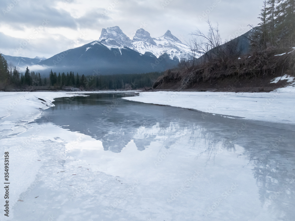 Fototapeta premium Winter mountain scenery with three peaks, landscape shot made at Three Sisters Mountain, Canmore, Alberta, Canada