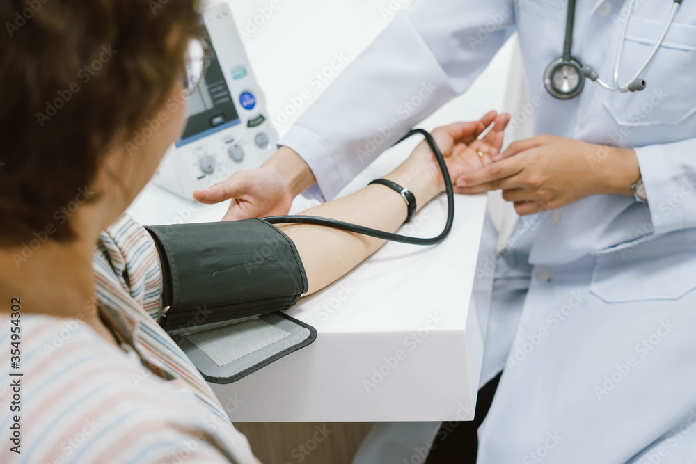 close up a doctor checking blood pressure of senior patient. close up a doctor checking blood pressure of senior patient.