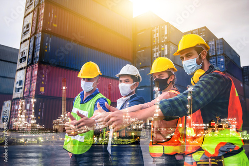 Engineer team people standing with their hands together at the container yard with oil and gas refinery background. Cargo freight ship for import and export. Team Teamwork Concept